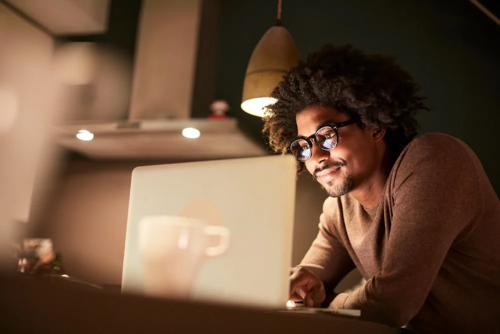 Male african american student looking at laptop, University of Connecticut Graduate Certificate - MS Degree - MA Degrees Online Courses